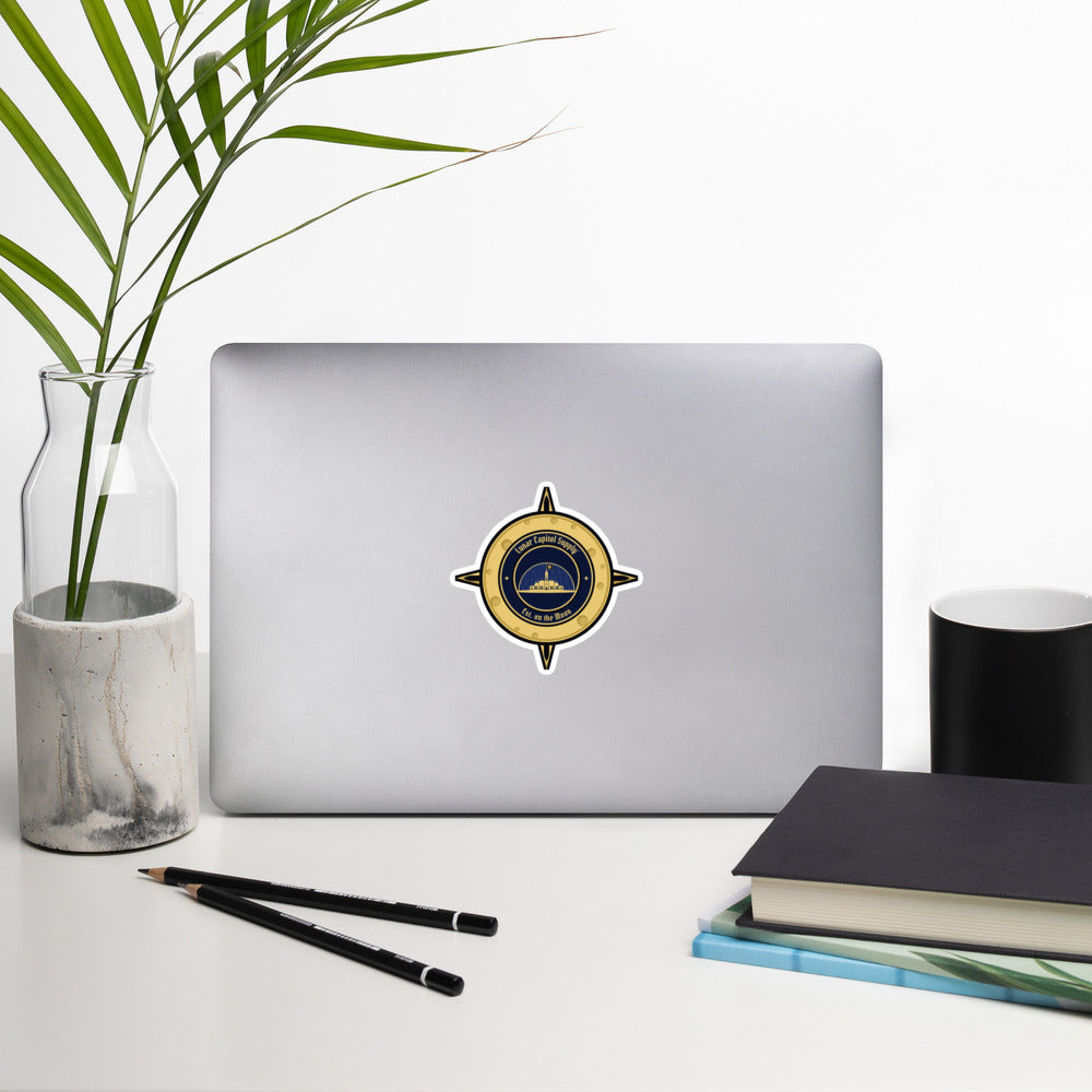 4 inch Lunar Capitol Dome Crest Sticker on the back of an open laptop on a white desk
