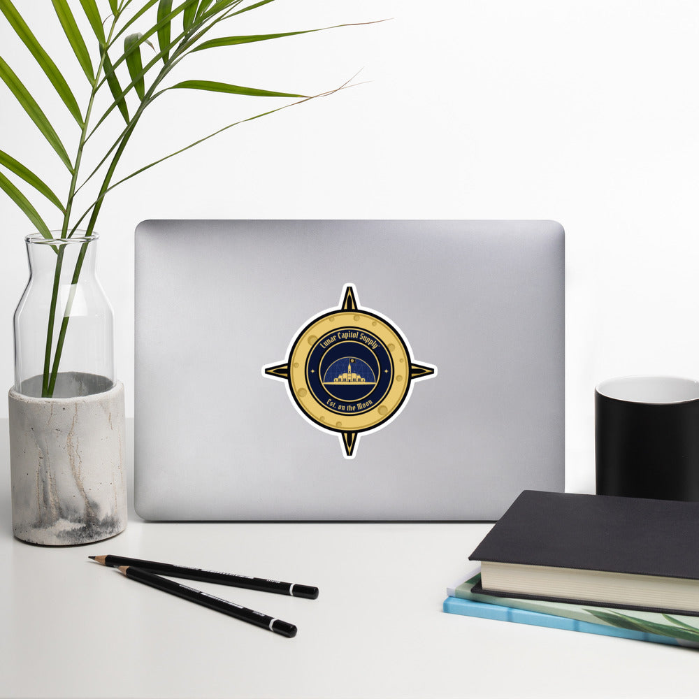 5.5 inch Lunar Capitol Dome Crest Sticker on the back of an open laptop on a white desk